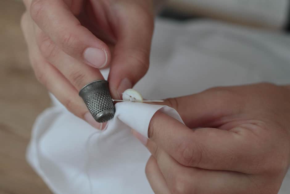 Mother-of-pearl button attached by hand Mother-of-pearl button attached to a bespoke shirt